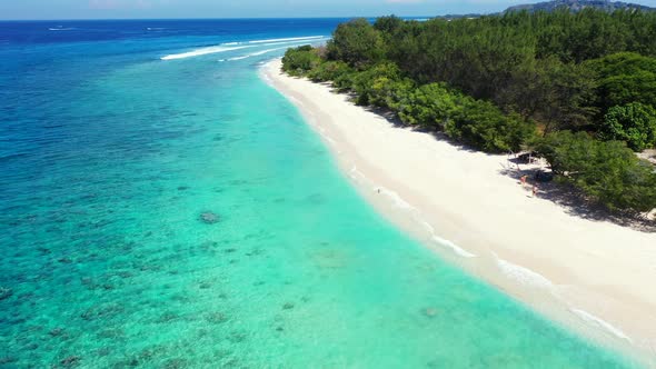 Wide angle above abstract view of a paradise sunny white sand beach and aqua blue ocean background 