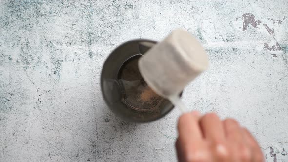 Serving A Portion Of Protein Powder and creatine Into The Shaker bottle