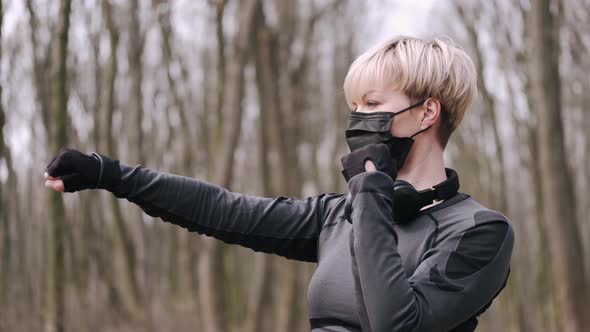 A Middle-aged Woman in a Mask Is Doing Morning Exercise Outside