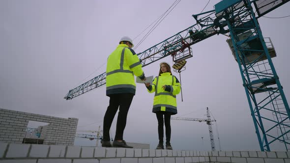 Architect and Foreman in Construction Site Woman Inspector is Giving Documentation to Civil Engineer alt