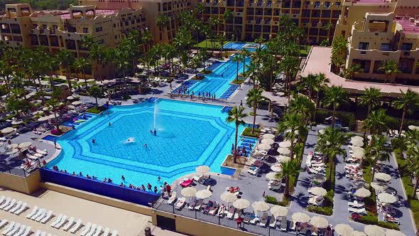 Drone footage of people relaxing and playing in a large resort pool. Footage captured in Cabo San Lu