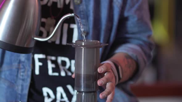 Employee Wearing Casual Working in Bar Pouring Hot Water Into Aeropress to Brew Coffee Close Up in