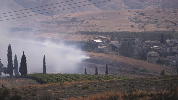 Thick smoke rising next to a village