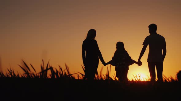 A Young Family with a Child Admiring the Sunset