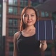 Young woman holding a solar cell in front of the camera while smiling - VideoHive Item for Sale
