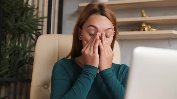 Woman Is Tired of Sitting at the Computer and Working. She Rubs Her Eyes with Fatigue