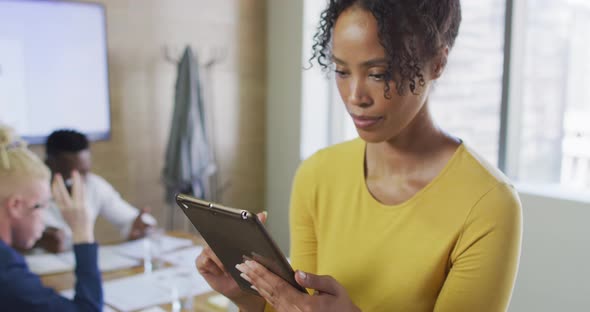 Portrait of happy african american businesswoman with tablet in creative office