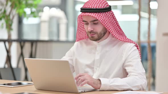 Focused Arab Businessman Working on Laptop in Office 