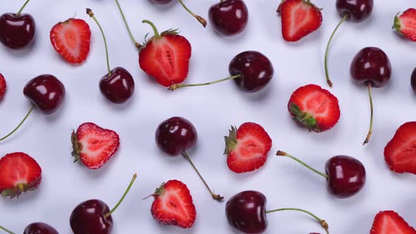 Rotating Background of Ripe Strawberries and Cherries on a White Background
