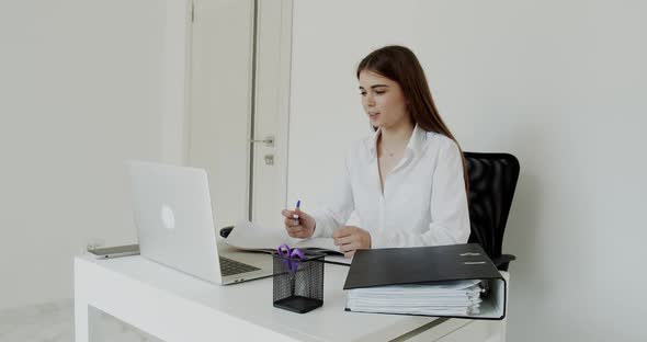 Cheerful Girl Having Online Consultation on Laptop at Workplace in Office