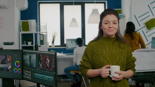 Portrait of Creative Designer Smiling at Camera Holding a Cup of Coffee