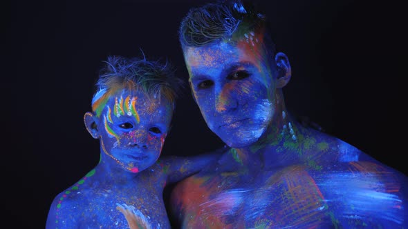 Young Father and Son Are Painted with UV Paint