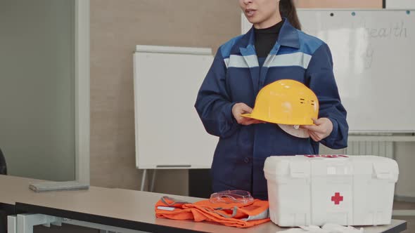 Woman In Coverall Talking Of Hard Hats Usage At Factory