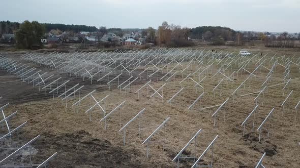 Aerial Footage of a Massive Field with Lots of Steel Racks for Solar Panels