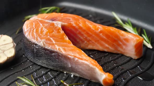 Fresh Salmon Steak on a Hot Grill Pan the Chef Pours Olive Oil 