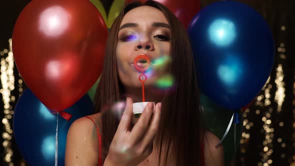 Birthday Celebration. Woman Blowing Soap Bubbles With Balloons