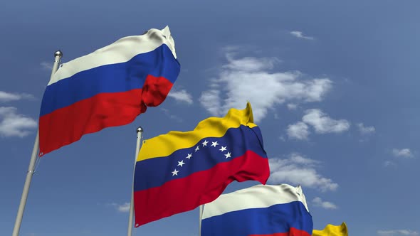 Waving Flags of Venezuela and Russia on Sky Background