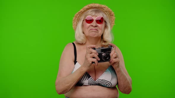 Senior Woman Tourist Photographer Taking Photos on Retro Camera and Smiling on Chroma Key Background