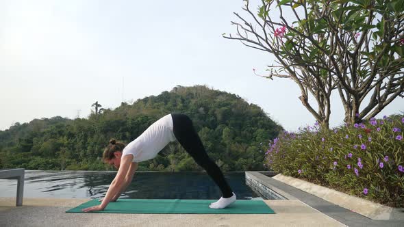 Brunette Woman Is Doing a Yoga Exercise Near the Pool. Novice Yogi