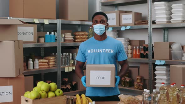 African American Man in Mask Holding Box for Donation