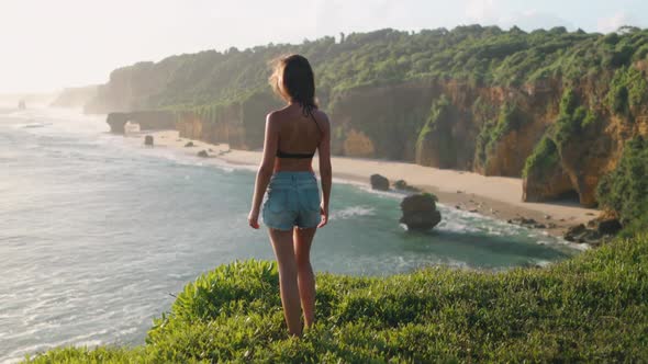 Woman Standing on Cliff Edge Tropical Banawa Beach