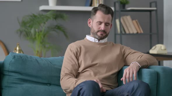 Man Taking Nap While Sitting on Sofa