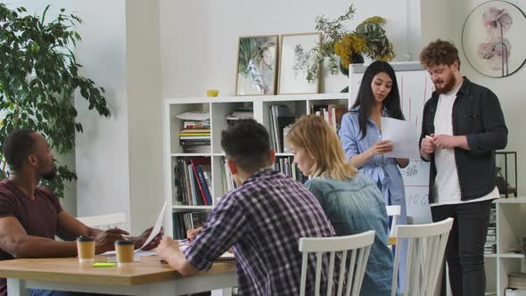 Serious Female Manager Executive and Diverse Team People Analyze Paperwork Talk Work Together Gather