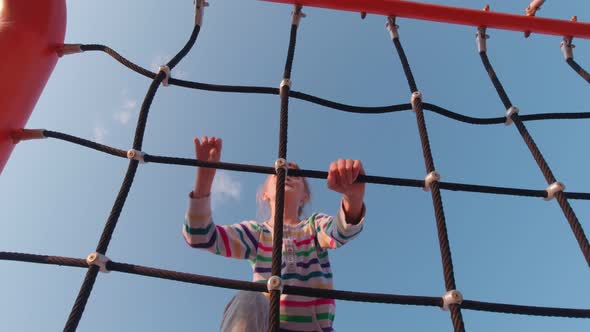 Happy Girl Climbing In Rope Park