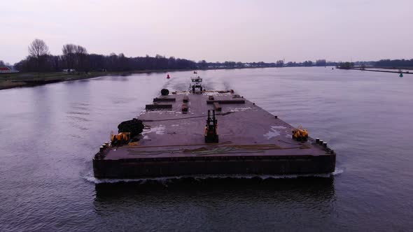 Aerial Around Forward Bow Of Barge With Fork Lift On It Being Transported By Push Boat On Oude Maas