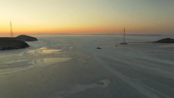 Drone View of the Ice-bound Strait with Tugboats Operating at Sunset