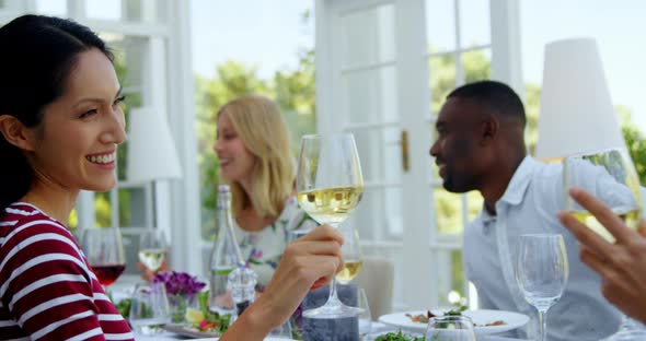 Two friends toasting glasses of wine in restaurant