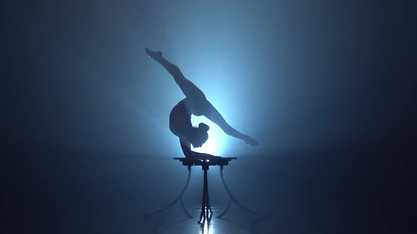 Girl Gymnast Performs Various Acrobatics on a Table