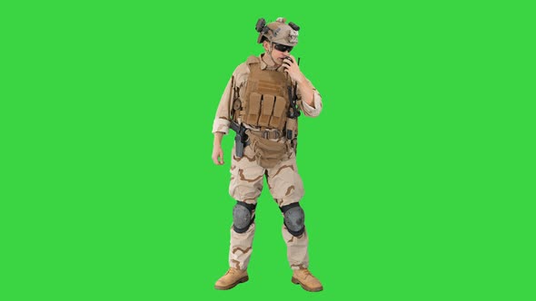 Soldier in Uniform Talking on Radio on a Green Screen, Chroma Key.