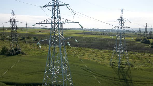 Drone Flying Over Agricultural Land and Electric High Voltage Pylon Against Beautiful Sky