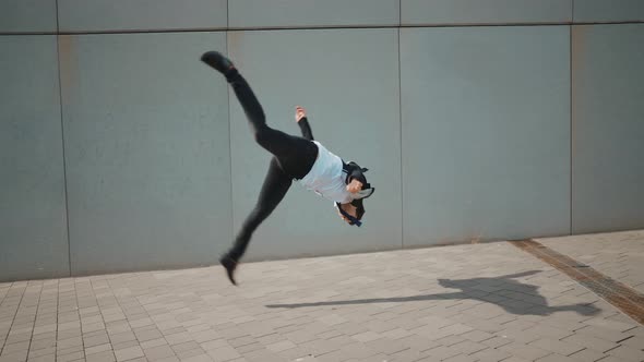 Flexible and cool businessman doing acrobatic tricks outdoor.