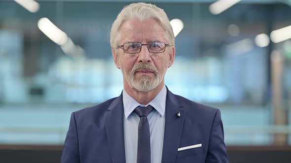 Portrait of Old Businessman Looking at Camera