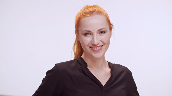 Caucasian Middleaged Female with Colored Orange Hair and Dark Brown Shirt Smiling Looking at Camera