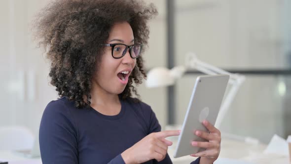 Portrait of African Woman Celebrating Success on Tablet