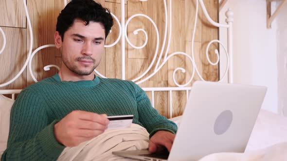 Man in Bed Excited for Successful Online Shopping Payment