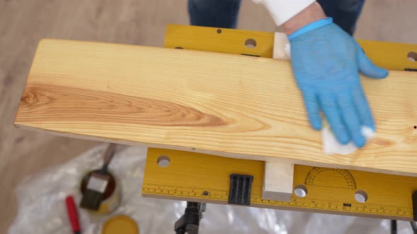 the Carpenter Rubs the Wood with Oil with a Napkin