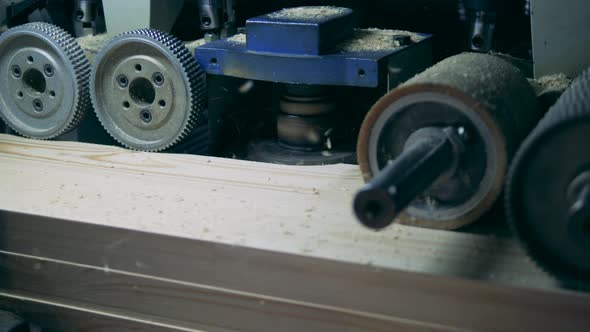 Industrial Mechanism with Revolving Gears Is Scraping Wood