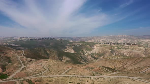 Aerial view of desert hills covered with green vegetation, drone shot.