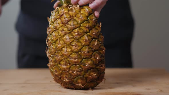 Close Up of Young Man Chef Hands Slicing a Pineapple in Kitchen Macro Super Male Female Fruits