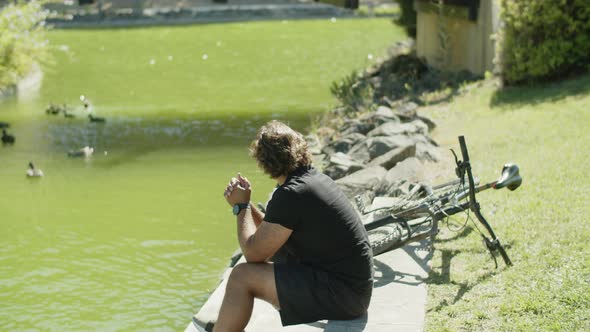 Side View of Man with Disability Watching Ducks in River