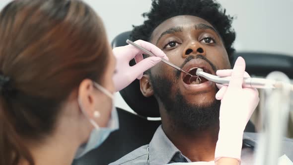 Dentist Examining a Patient's Teeth in the Dentist Office