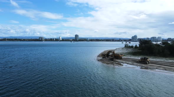 Large mining machines working on the edge of an island dredging sand from a ocean boating channel. H