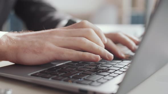 Hands of Businessman Typing on Laptop at Office Workplace