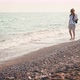 A Young Woman Walking Barefoot on the Beach During Sunset - VideoHive Item for Sale