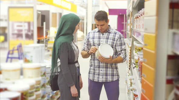 Seller Consultant in the Supermarket Advises a Muslim Woman