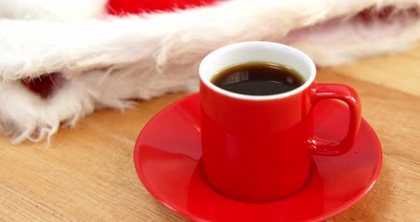 Close-up of coffee cup with saucer and santa hat 4k